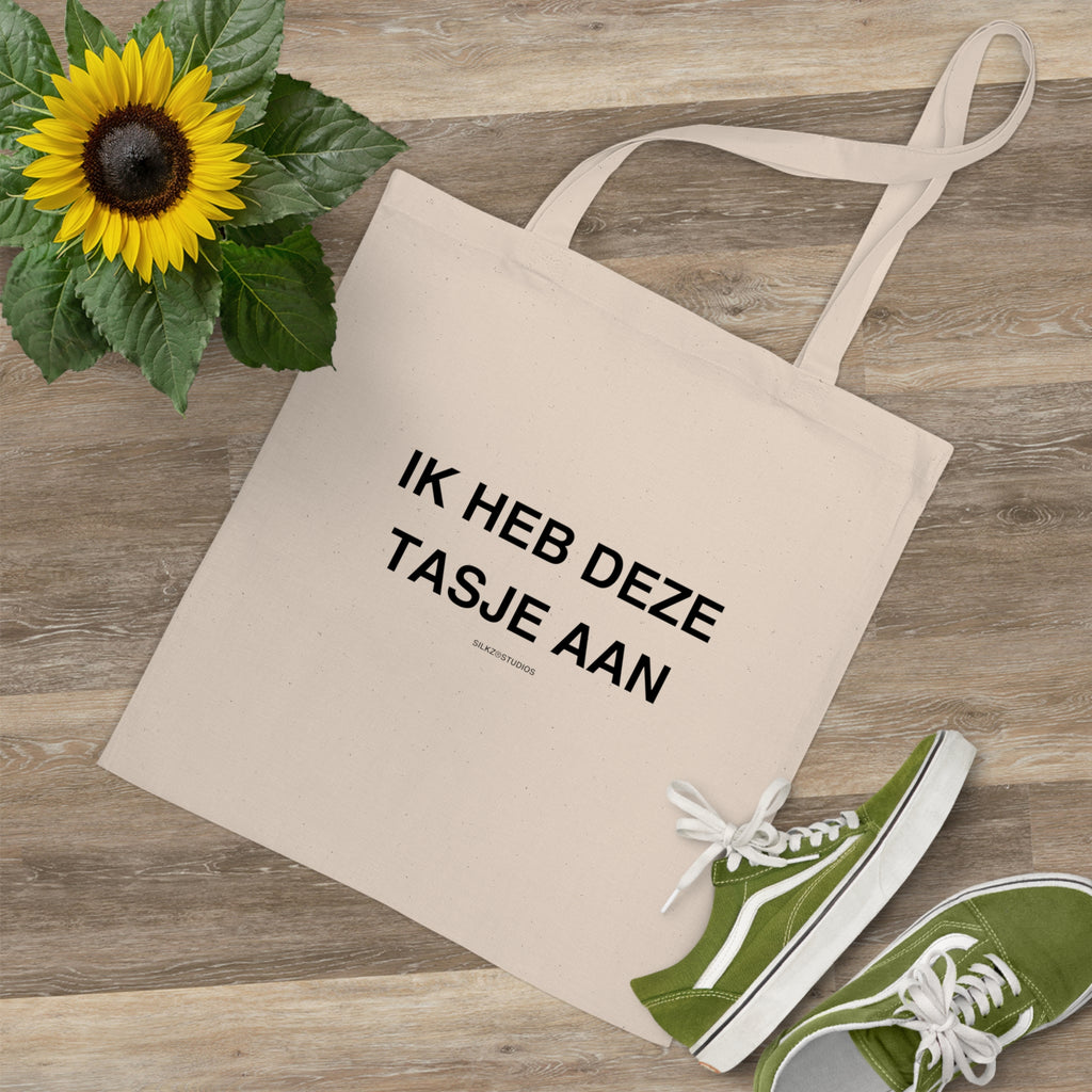 Naturale katoenen tas met tekst ik heb deze tasjes aan tote bag liggend naast groene schoenen en zonnebloem